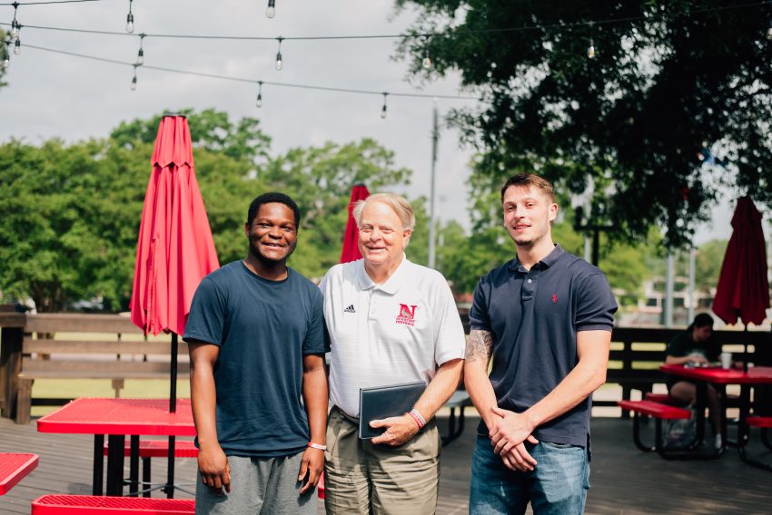 Dr. Morrie Scherrens, president of Newberry College, poses with two students on Ernie's Porch during Scarlet & Gray Week 2022