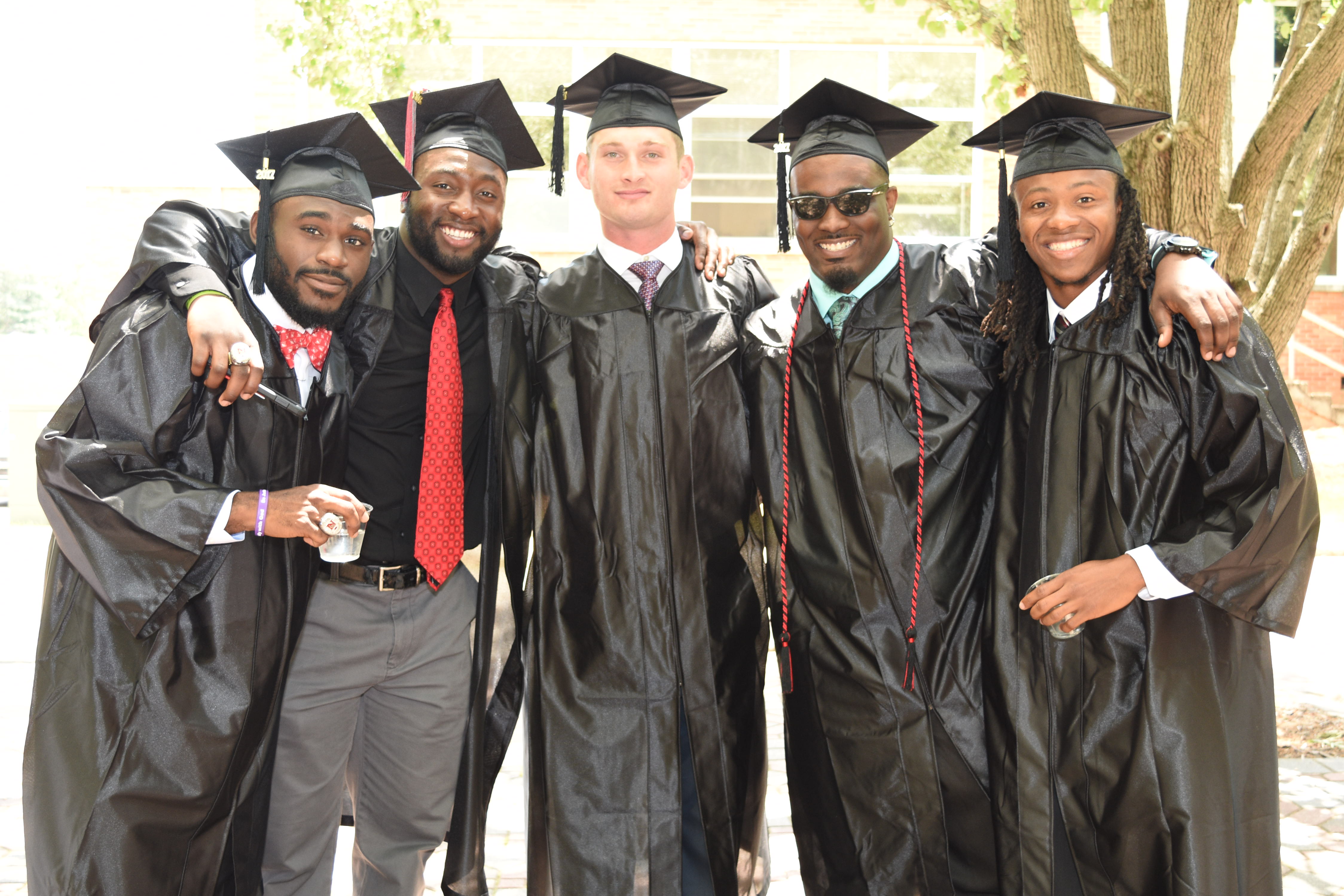 Five graduates in cap and gown