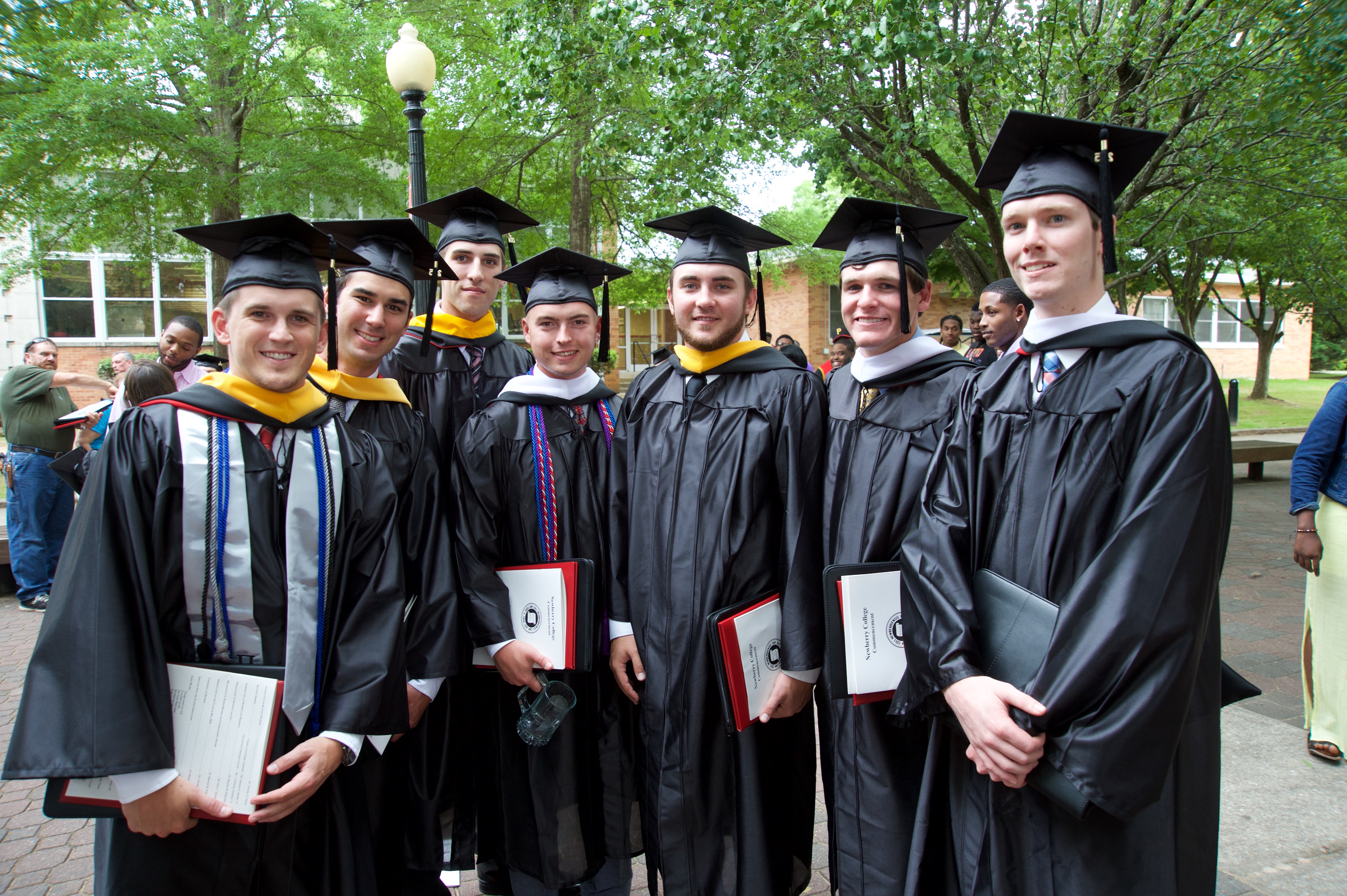 Seven graduates in cap and gown