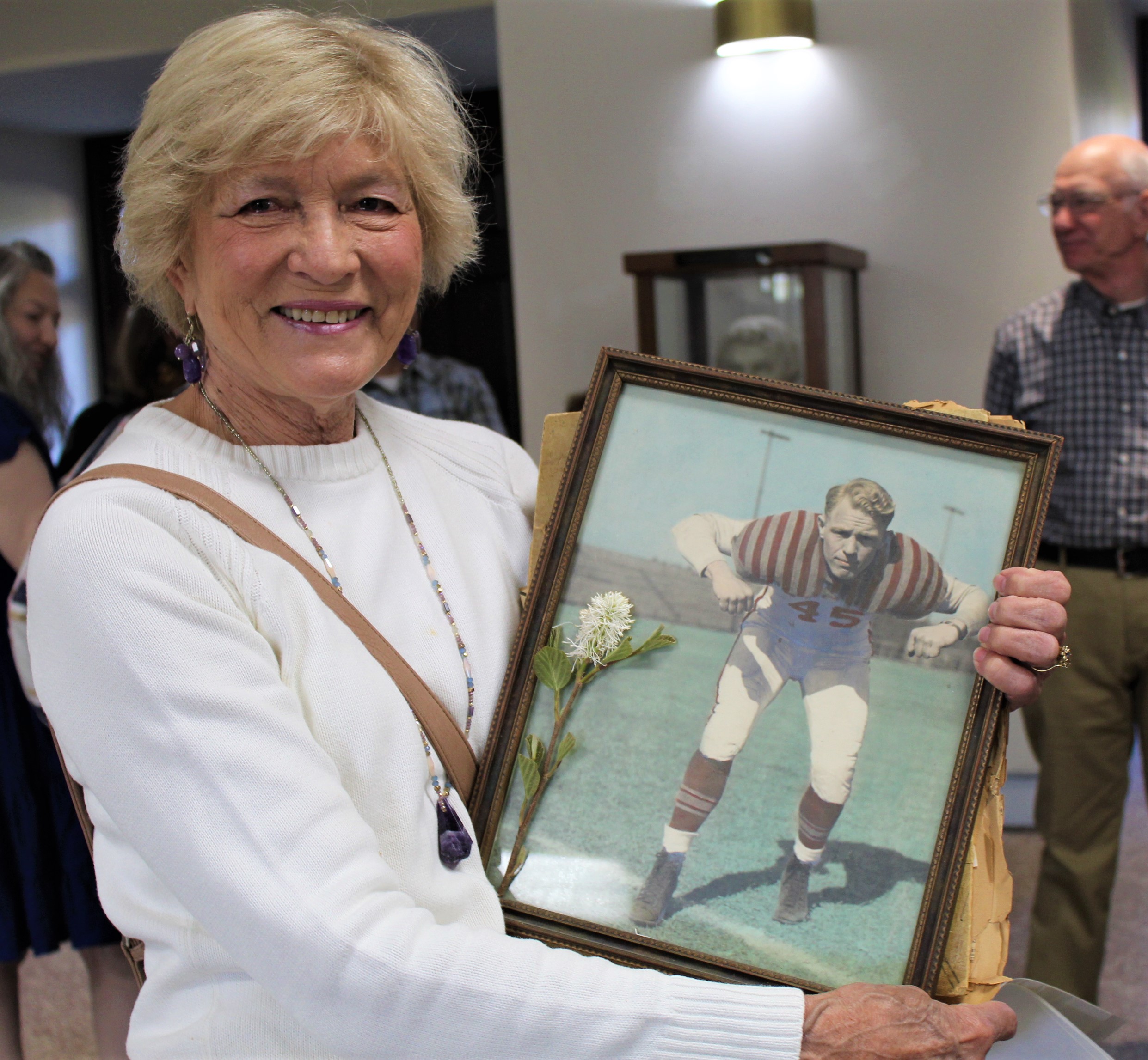 Sandra Corley Bandy with a photo of her father, Buddy Corley, in his football uniform