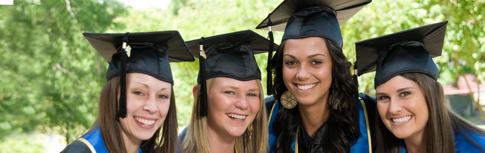 group of 4 female graduates in cap and gown