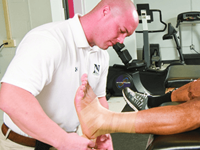 athletic trainer wrapping an ankle